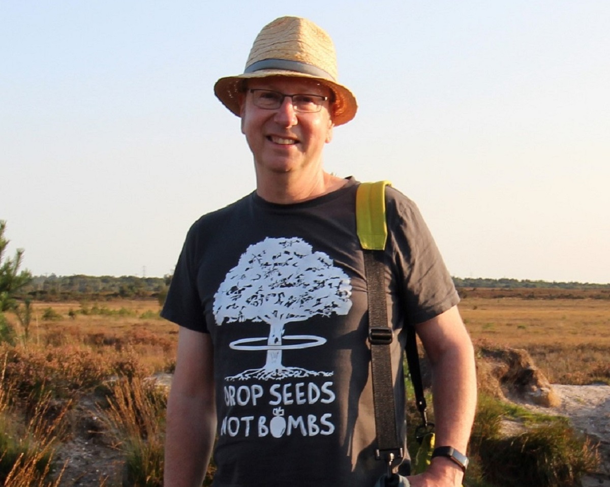 man in a straw hat and tshirt with 'dorp seeds not bombs' written on it